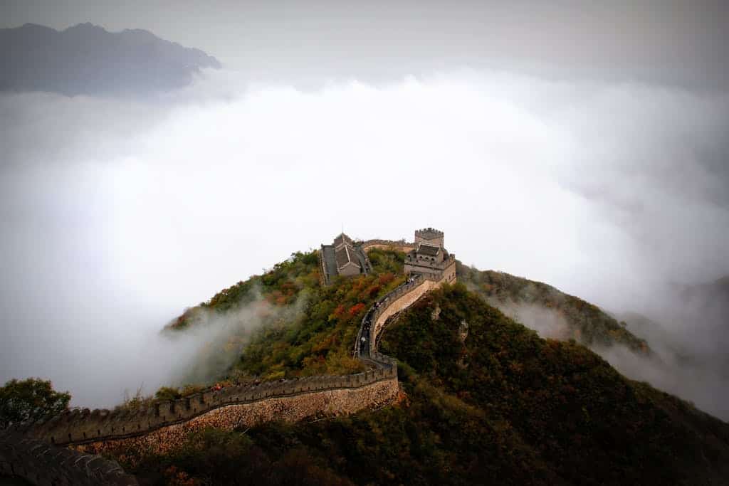 Majestic aerial shot of the Great Wall of China surrounded by mist and mountains.