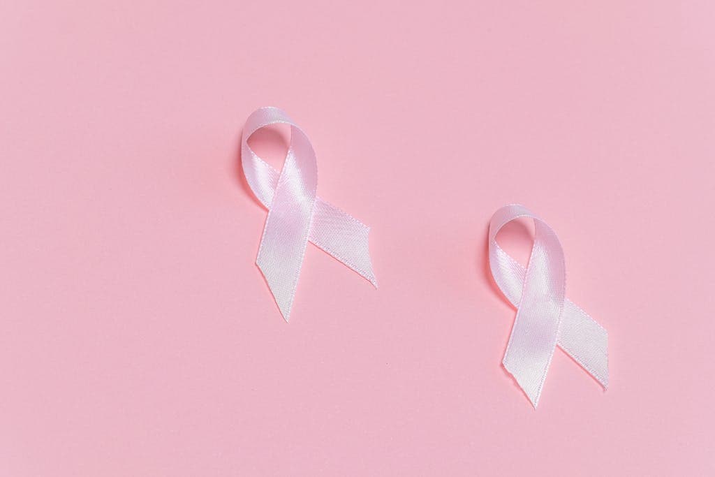 Pink ribbons symbolizing breast cancer awareness on a pink background.