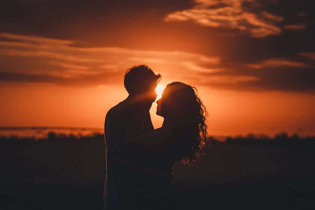 Romantic silhouette of a couple embracing at sunset, ideal for love and romance themes.