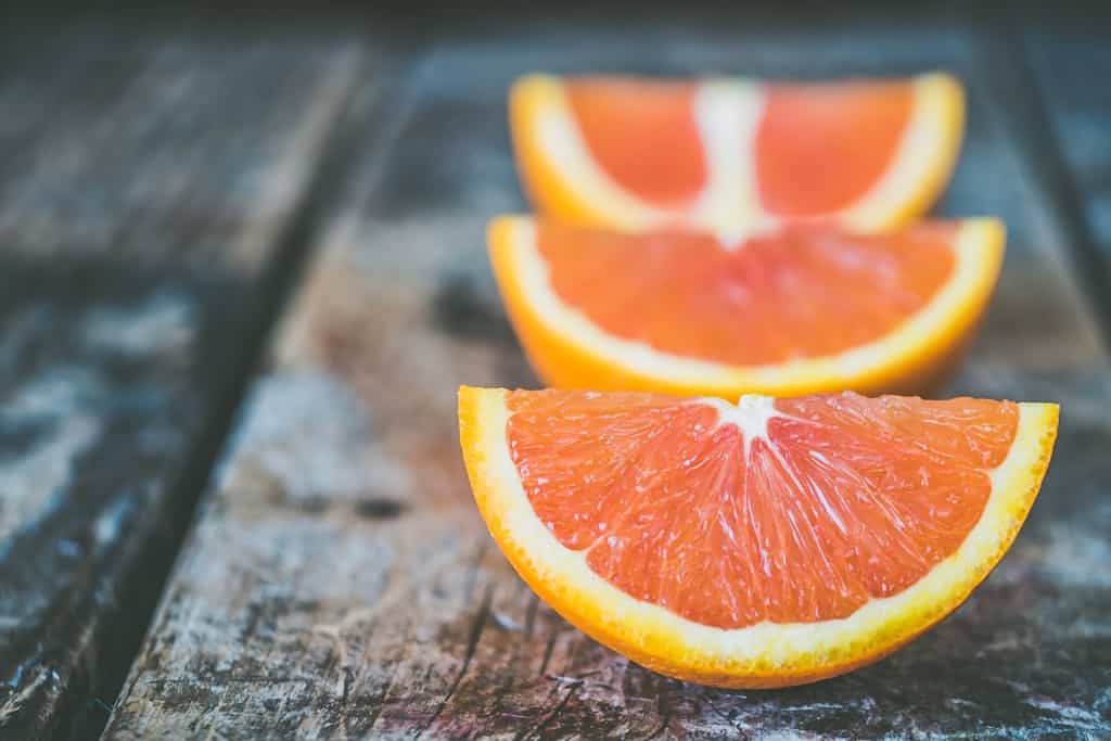Vibrant orange slices arranged on a rustic wooden table capturing a healthy lifestyle theme.